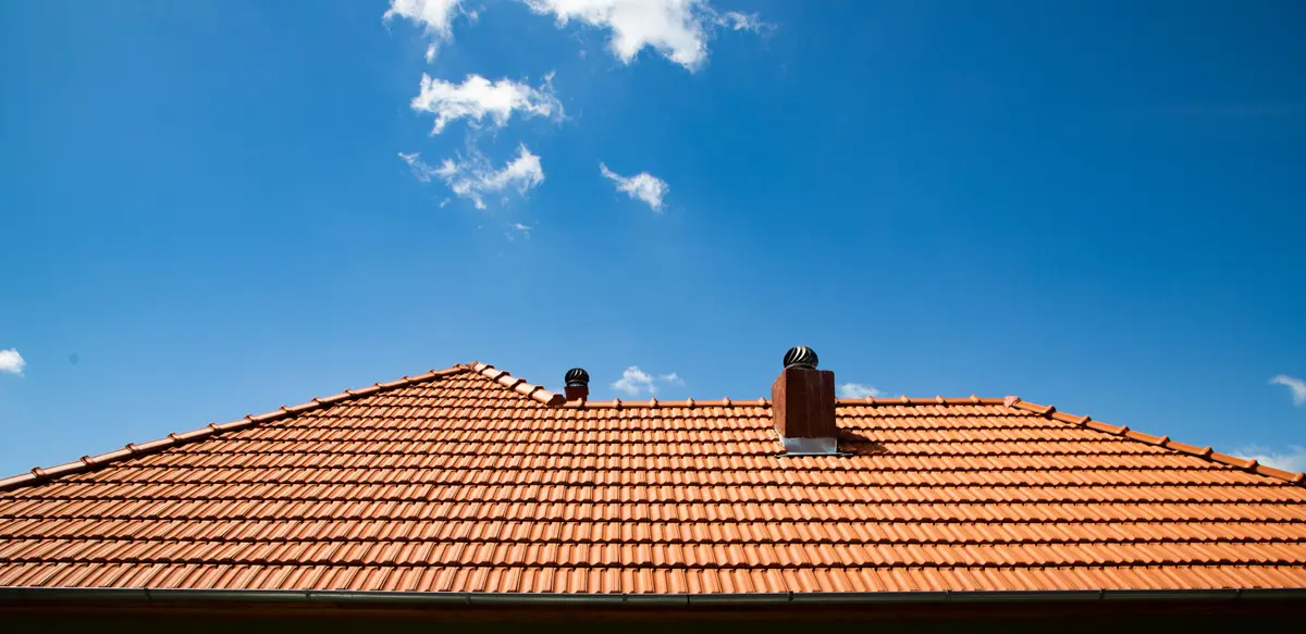 Red clay tile roof under a blue sky