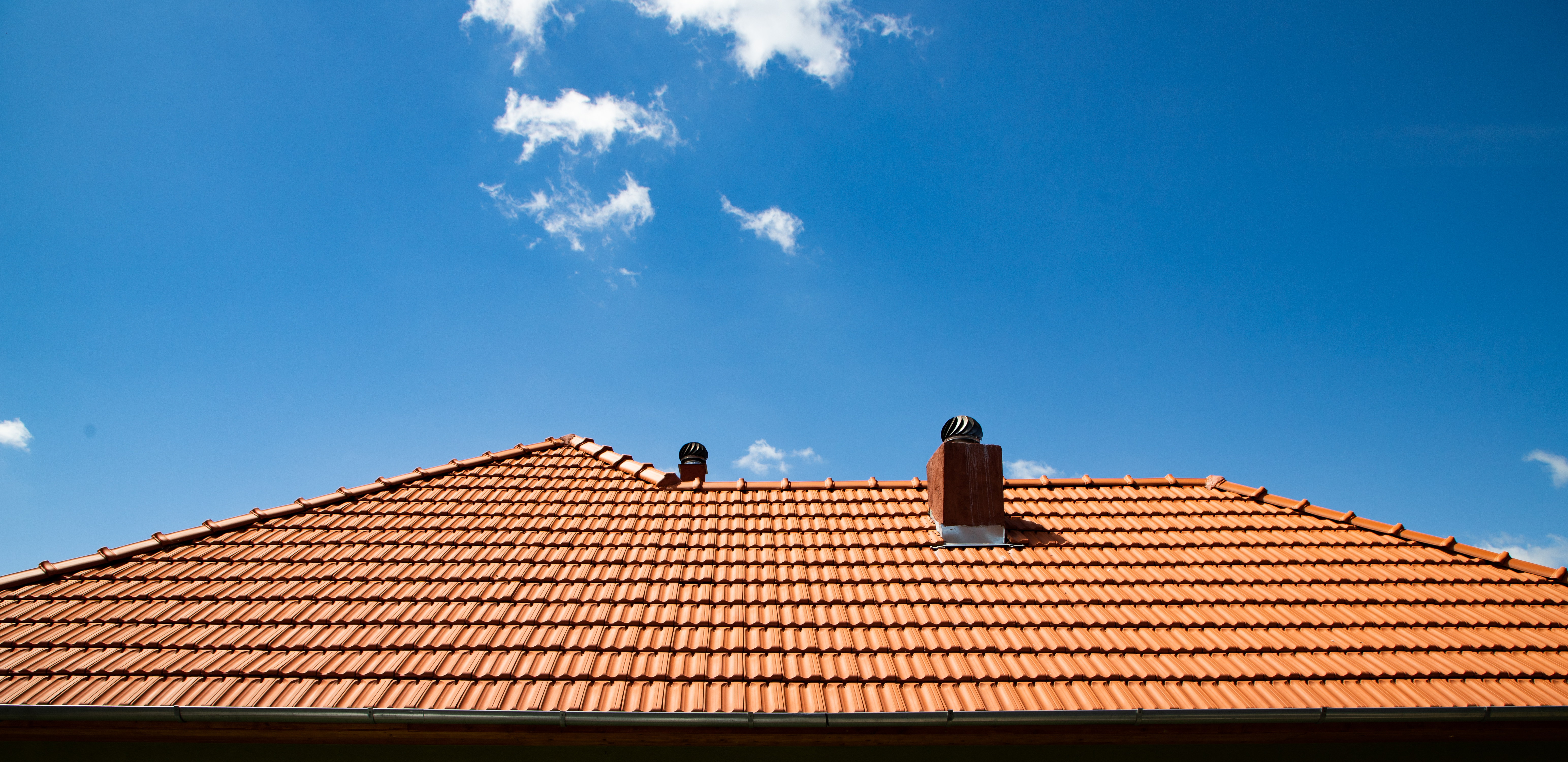 New red tile roof against a blue sky